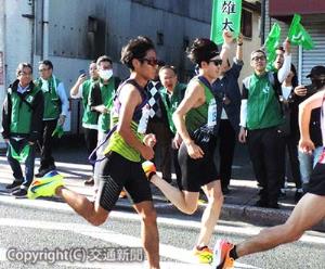 ＪＲ東日本グループ社員・家族らの声援を受け、左腕を挙げて応える中山選手（中央、３区）