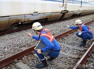 列車が在線した状態で脱線防止ガードの状態を点検する作業員