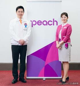 ピーチのキャビンアテンダントと記念撮影する吉村知事（ピーチ・アビエーション提供）