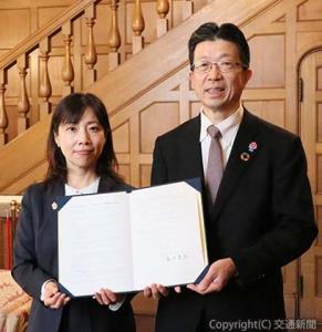 協定書を手にする（右から）嶋田社長と瀧澤市長（阪急阪神ホールディングス提供）