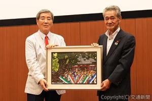 萩原氏から切り絵作品を受け取った半井理事長（右）＝遍路とおもてなしのネットワーク提供＝
