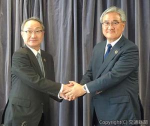 固い握手を交わす小坂新社長（右）と山村取締役