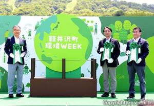 環境へのメッセージを書いたリボンを掲げる喜㔟社長（中央）、西山社長兼ＣＯＯ（右）、土屋町長