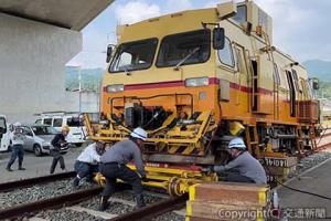 走行不能の確認車をジャッキアップし、台車枠を搬送台車に載せる競技者