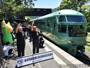 ホームで一斉に出発合図を送る石橋駅長（右）と１００人の１日駅長ら