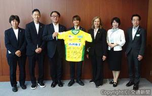 記念撮影する喜㔟社長（左から３人目）、カルメレ監督（同５人目）、林選手（中央）ら