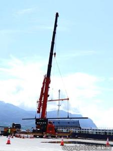 運搬船（右）からトレーラーにレールを積み替える陸揚げ作業