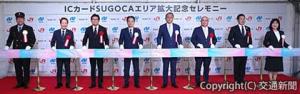 〝テープつなぎ〟でエリア拡大を祝った古宮社長（左から４人目）、大石知事（同５人目）ら