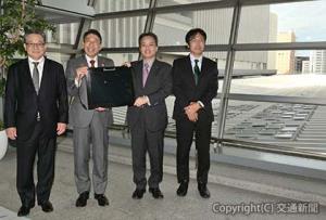 実証実験を開始したホーム屋根を背に記念撮影する古宮社長（右から２人目）、服部知事（同３人目）ら