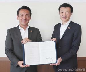 協定書を掲げる小川社長（右）と澁谷市長（西武鉄道提供） 