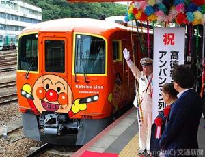 関係者が見守る中、出発合図を送る三谷駅長