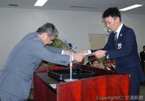 長戸専務（左）から表彰状を受け取る受章者代表