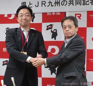 会見後に握手する古宮社長（右）と木村知事