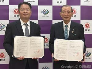 協定書を掲げる野本会長（右）と長崎知事