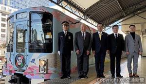 池袋駅７番線ホームで「52席の至福」と記念撮影を行う三日月知事（中央）、西山社長（右から２人目）ら