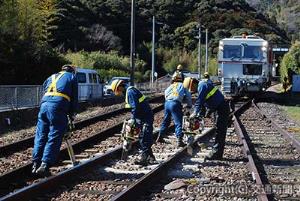 阿波大宮駅構内のＭＴＴ（後方）と人力によるバラスト突き固め作業