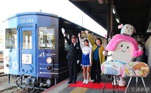 出発合図する三谷駅長（左端）、やすこーんさん（左から３人目）ら