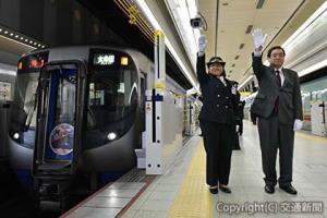 出発合図する最明副会長（左）と山口管理駅長