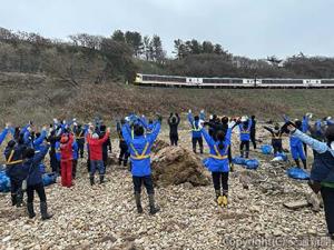 観光列車「リゾートしらかみ３号」に向けて手を振り、乗客への〝おもてなし〟も行った（JR東日本秋田支社提供）