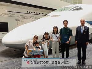 記念撮影する岡部館長（右端）と７００万人目の入館者