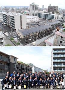 ㊤一体開発の全景。手前の３階建ての建物が一般賃貸住宅、中央左の６階建てがサ高住、右奥の５階建てが学生会館㊦まちづくりへ力を合わせる四之宮和幸ＪＲ四国社長（前列左から６人目）ら関係者（記念式典後）