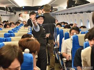 防護盾で不審者を制し、乗客を避難誘導する乗務員