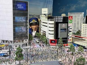 ビルの谷間から顔を出す吉川さん。ミニチュアのスケール感がよく分かる