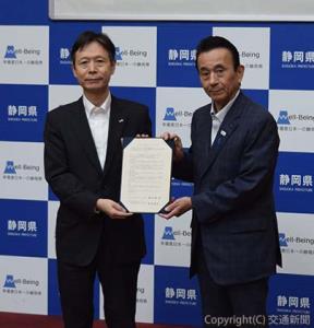 協定書に署名した丹羽社長（左）と鈴木知事