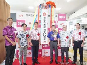 くす玉を開花した古宮社長（右から３人目）ら