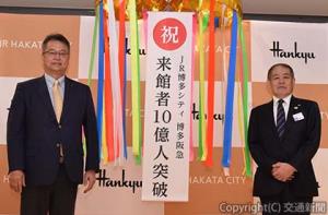 10億人達成を祝う赤木社長（左）と亀井店長