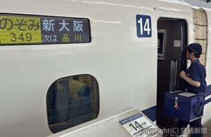 保冷ケースに収められた再生医療用の細胞加工物を車内へ運ぶ係員（ジェイアール東海物流提供）