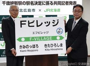 新駅の駅名標ボードを掲げるＪＲ北海道の綿貫泰之社長（右）と北広島市の上野正三市長