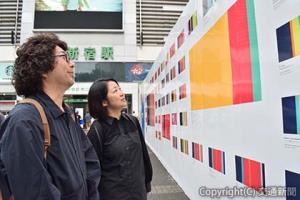 「Ｌｉｆｅ　Ｓｔｒｉｐｅ」を見つめる小林さんと山田さん